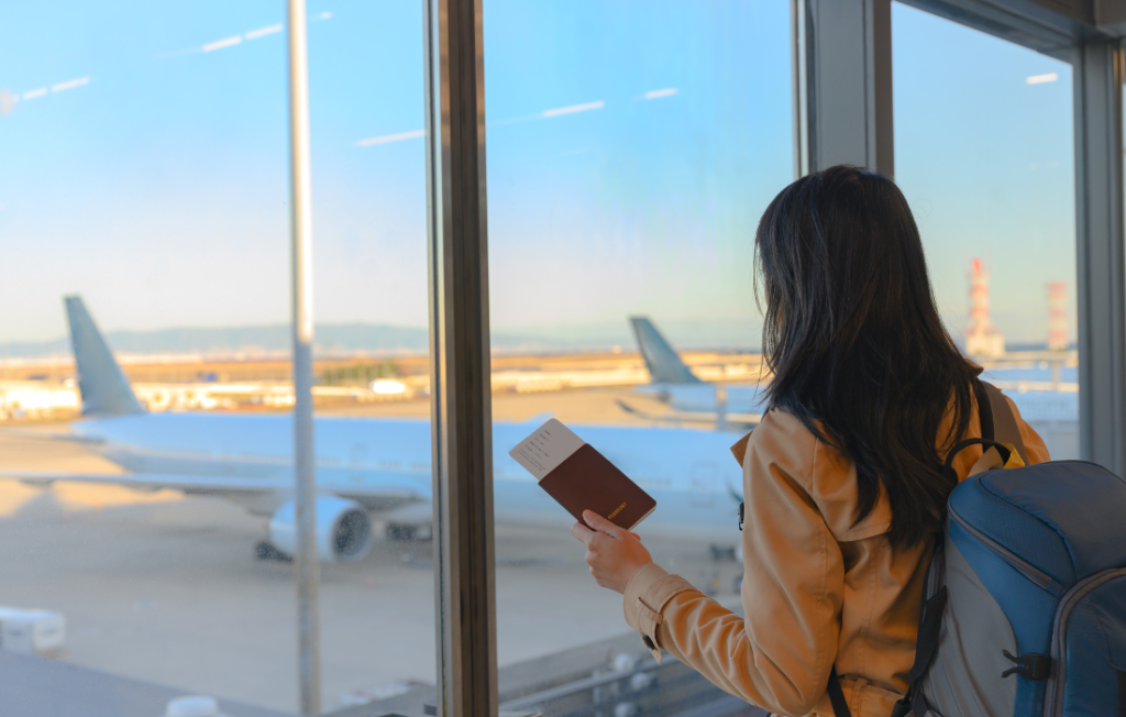 Mulher dentro de um aeroporto olhando um avião